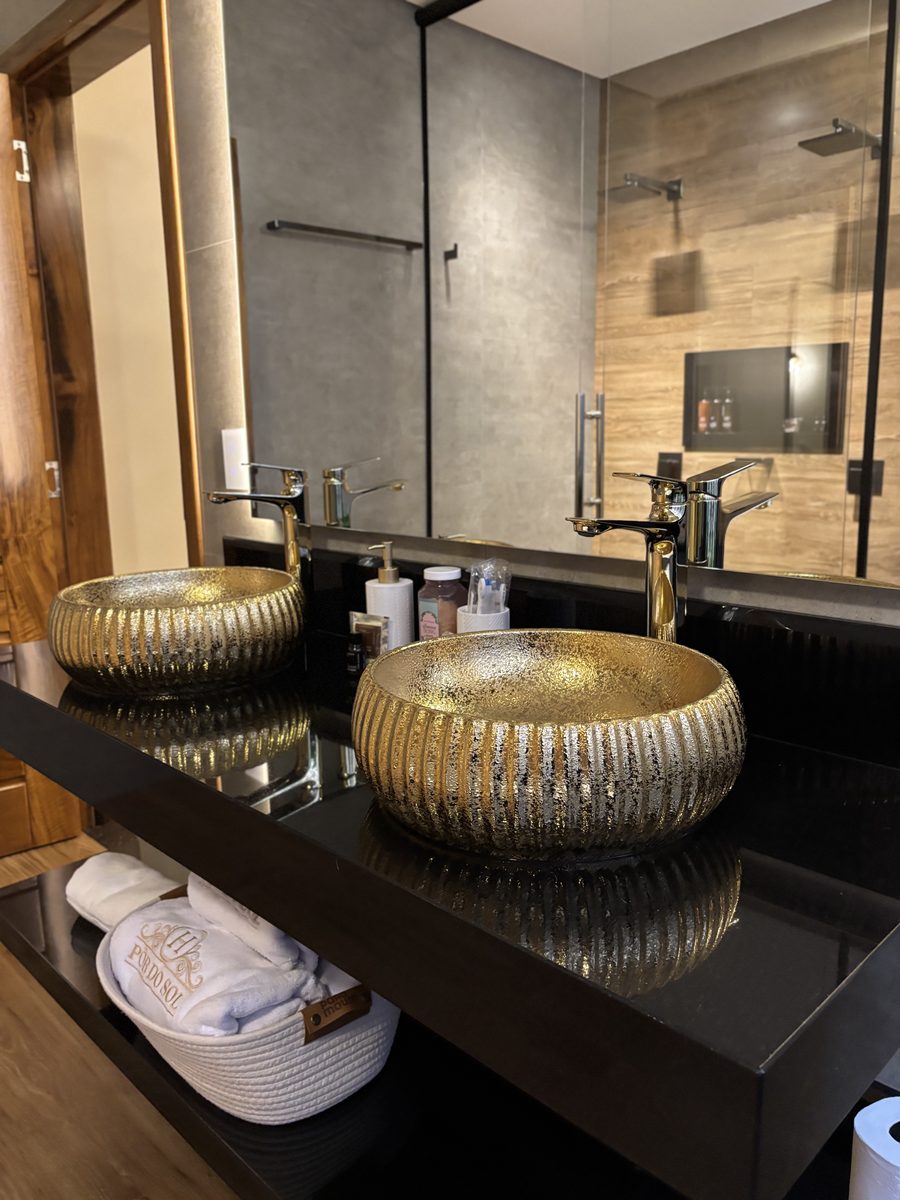 Baño con bachas doradas y amenities