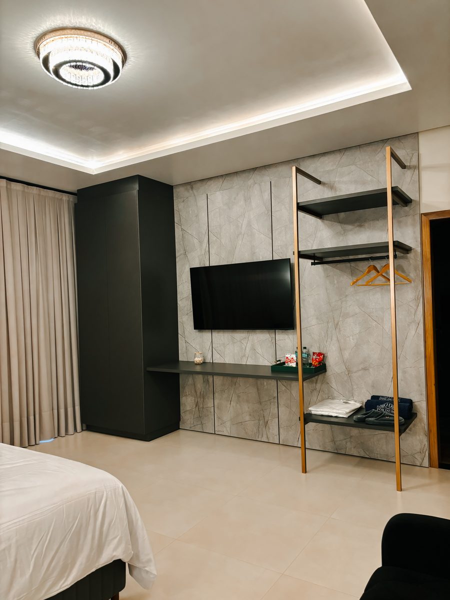 Habitación con pared de mármol, TV y perchero