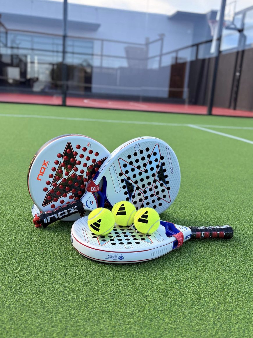 Paletas y pelotas en la cancha de pádel del hotel