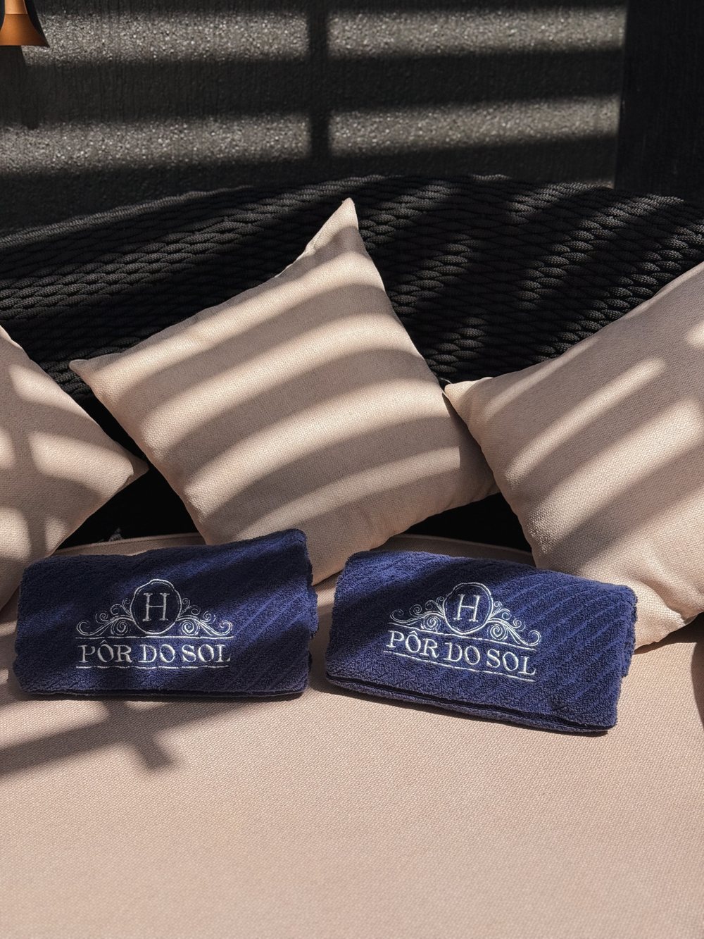Toallas del hotel sobre el daybed junto a la pileta