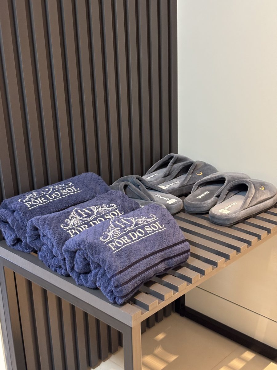 Toallas y pantuflas del hotel sobre el banco